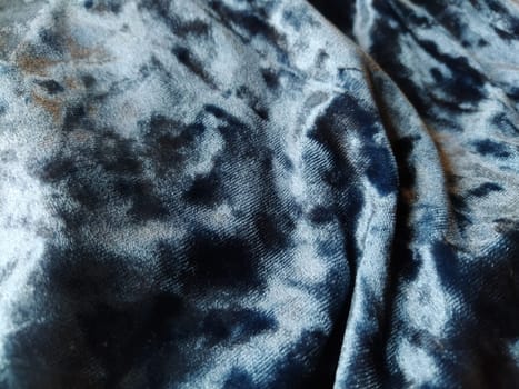 Velvet velor cloth background with glowing light and dark shadows. Background for theater and fashion design themes. Nice blue fabric with overflow.