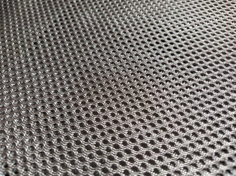 Abstract black nylon synthetic fabric. Gray artificial fabric mesh, resistant to pollution. Fragment of a child car seat close-up. Soft focus.