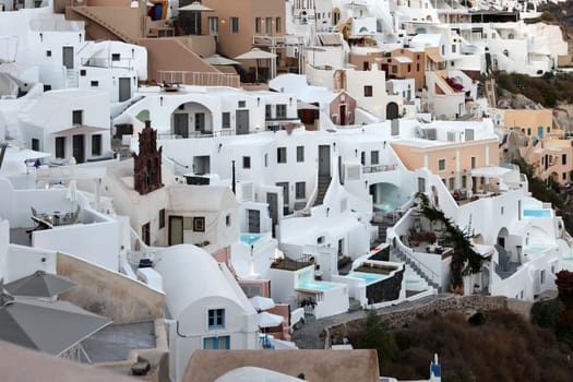 Oia, Santorini, Greece - June 28, 2021: Whitewashed houses with terraces and pools and a beautiful view in Oia on Santorini island, Greece