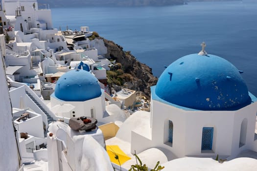 View from viewpoint of Oia village with blue dome of  greek orthodox Christian church. Santorini, Greece