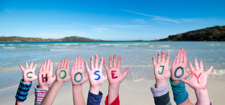Children Hands Building Colorful English Word Choose Joy. Summer Ocean, Sea And Beach As Background