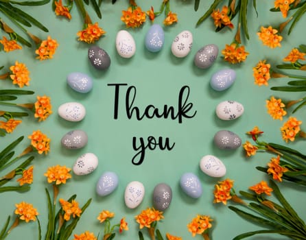 Flat Lay With English Text Thank You. Easter Egg Decoration With Orange Spring Flowers. Light Green Paper Background.