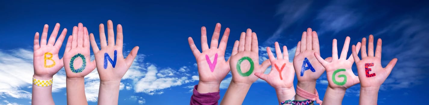 Children Hands Building Colorful French Word Bon Voyage Means Have A Good Trip. Blue Sky As Background