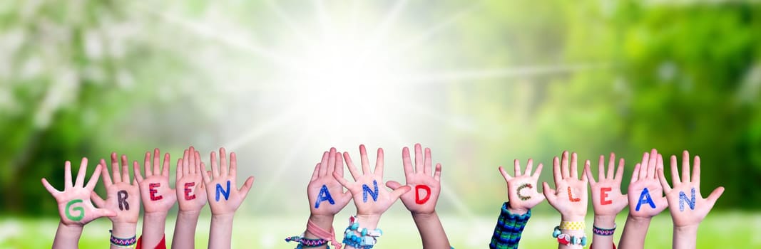Children Hands Building Colorful English Word Green And Clean. Sunny Green Grass Meadow As Background.