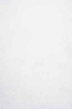 Background image of white uneven concrete surface. Top view. Copy space. Vertical