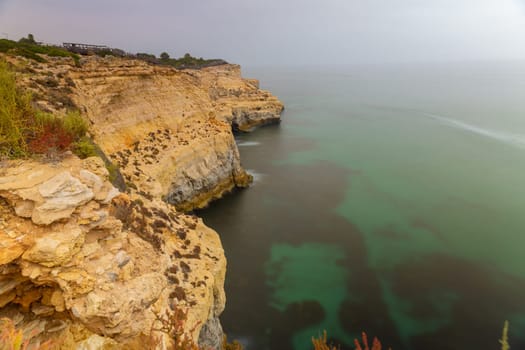 The famous coastline of Algarve in Portugal with Sandstone Cliffs lonely beaches Caves at Algar Seco