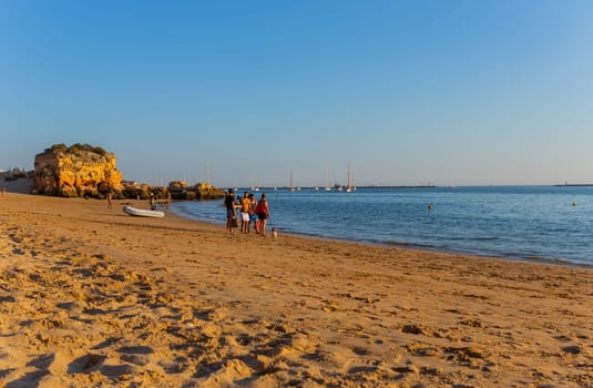 Ferragudo, Portugal - 25 August 2025: Beautiful seascape with beach, cave and ocean. Praia Grande beach. Ferragudo, Lagoa, Algarve, Portugal