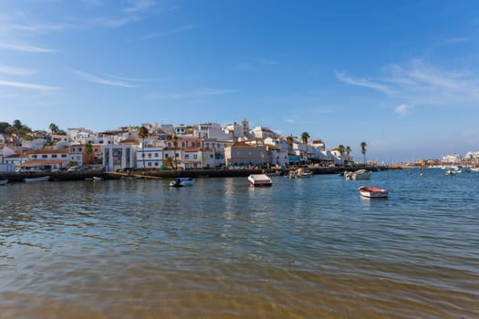 Ferragudo, Portugal - August 25, 2022 - View of the white town with boats moored in the foreground, Ferragudo, Algarve, Portugal, Europe