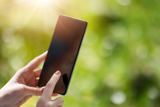 Closeup view of the woman's hands holding smartphone. Concept of the background, wallpaper and backdrop.