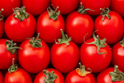 Background image of lying rows of red ripe cherry tomatoes. Top view. Flat lay. Copy space