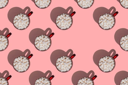 Pattern of red cups with hot chocolate, coffee or cocoa with marshmallows with hard shadows isolated on light pink background. Top view. Copy space