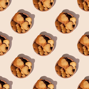 Seamless endless pattern of heart shaped gingerbread cookies in wooden bowl with hard shadows isolated on light pink background. Top view