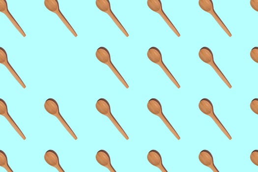 Pattern of wooden spoons with hard shadows isolated on light blue background. Copy space. Top view