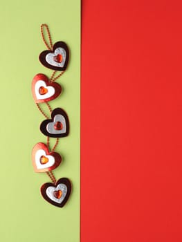 Heart decoration on green and red paper background with space for text