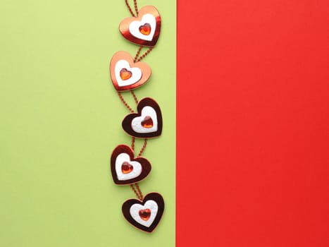 Heart decoration on green and red paper background with space for text