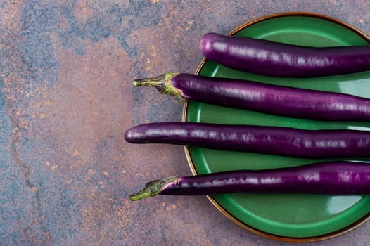 Raw small eggplants on the kitchen table.