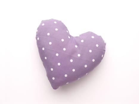 Pink dotted fabric heart shape, love symbol, close up studio shot, Valentines Day or wedding object