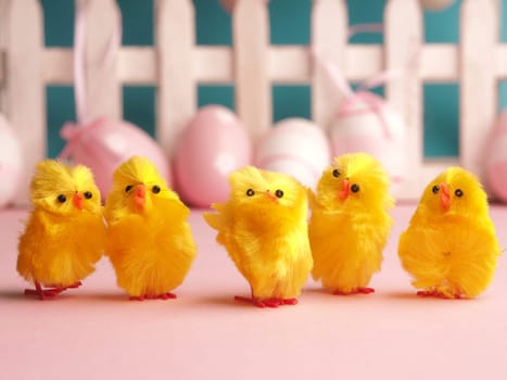 Close up of five cute chicks with Easter eggs background