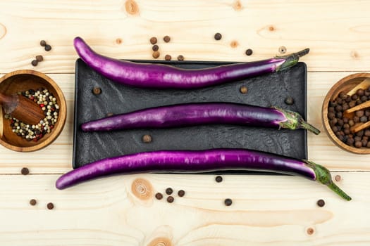 Raw small eggplants on the kitchen table.
