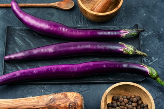 Raw small eggplants on the kitchen table.