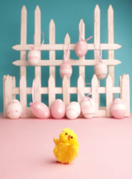 Close up of cute chick with Easter eggs background