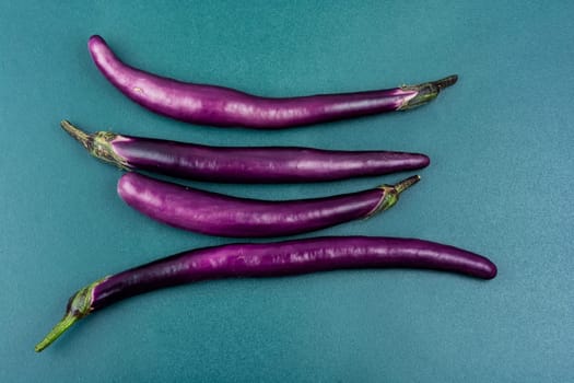 Raw small eggplants on the kitchen table.