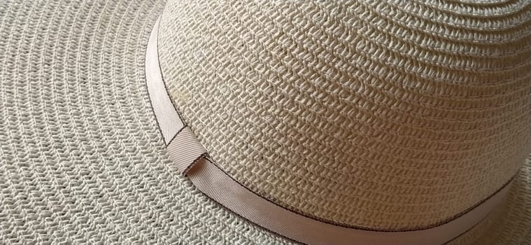 Hatband. A strap or adornment on the headdress. Straw hat close-up. Travel and leisure theme. Summer holiday. View from above