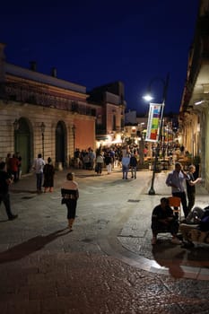 Matera, Italy - September 15, 2019: Tourists during a walk on Cobblestone street in the Sassi di Matera a historic district in the city of Matera. Basilicata. Italy