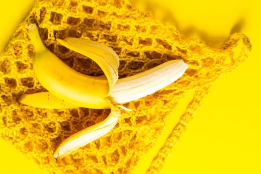 A string bag with bananas isolated on yellow background.