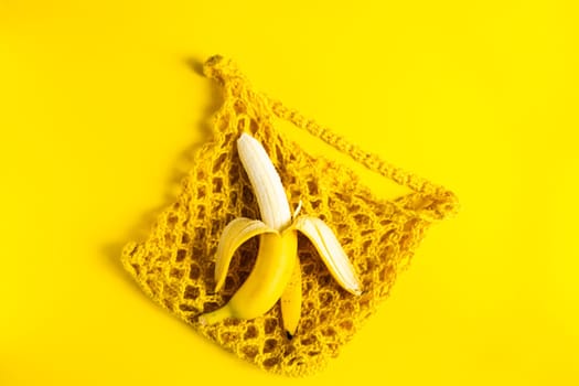 A string bag with bananas isolated on yellow background.