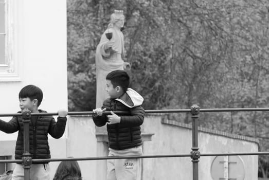 Grayscale shot of two asian kids in a museum in Prague, Czech Republic