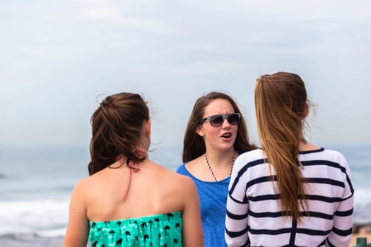 Teenagers girls at beach holidays talk laughter swimming sea ocean waves