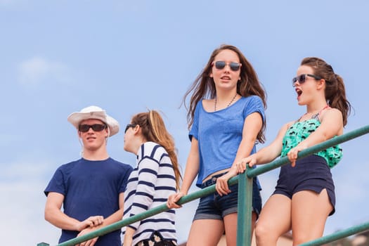 Teenagers boy girls at beach holidays talk laughter fun