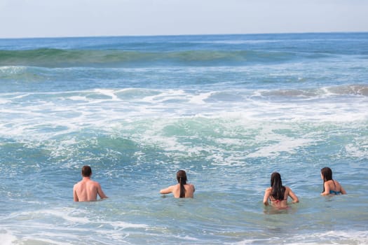 Boy Girls teenagers at beach swimming sea ocean shorebreak waves fun