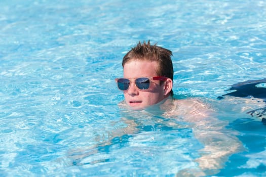 Boy teenager swimming pool summer fun.