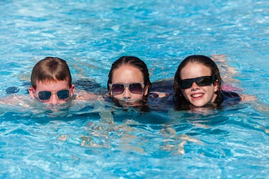 Girl Boy teenagers at beach pool summer holidays talk laughter swimming happy fun.