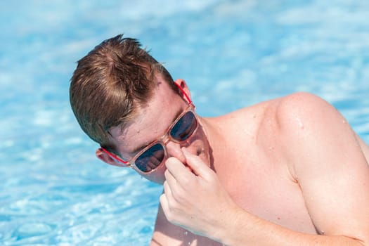 Boy teenager swimming pool summer fun.
