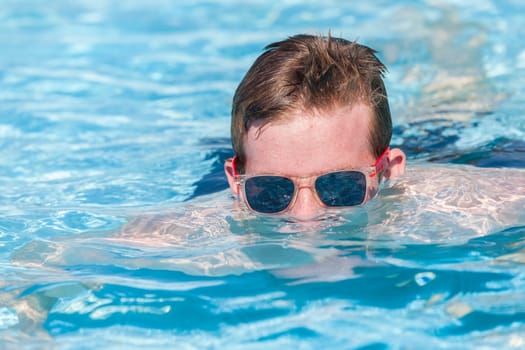 Boy teenager swimming pool summer fun.