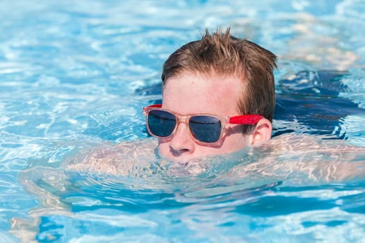 Boy teenager swimming pool summer fun.
