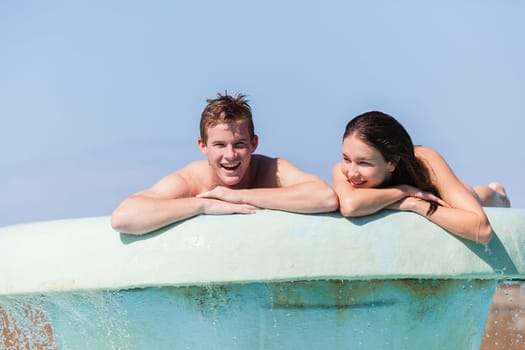 Girl Boy teenagers at beach pool summer holidays talk laughter swimming happy fun.