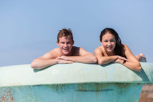 Girl Boy teenagers at beach pool summer holidays talk laughter swimming happy fun.