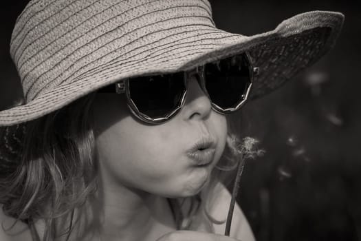 Portrait of a blonde girl with hat and sunglasses black and white