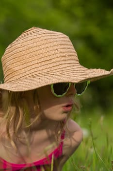 Portrait of a blonde girl with hat and sunglasses