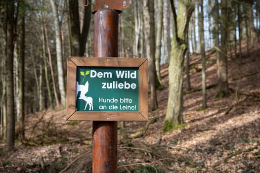 German sign at a wildlife park For the sake of the wild, please keep the dogs on a leash