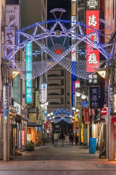 ikebukuro, japan - december 31 2019: Night view of the illuminated entrance gate of the Sunshine Central Street connecting the east exit of Ikebukuro station lines with restaurants and shops leading to the famous otome road decorated for new year.