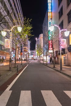 ikebukuro, japan - december 31 2019: Night view of the Christmas illuminations on the lampposts of the Sunshine Street at the east exit of Ikebukuro train station with illuminated neon signs.