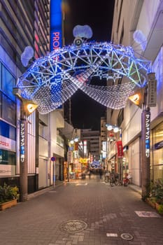 ikebukuro, japan - december 31 2019: Night view of the illuminated entrance gate of the Sunshine Central Street connecting the east exit of Ikebukuro station lines with restaurants and shops leading to the famous otome road decorated for new year.