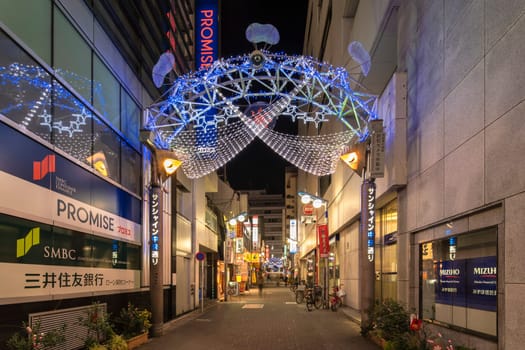 ikebukuro, japan - december 31 2019: Night view of the illuminated entrance gate of the Sunshine Central Street connecting the east exit of Ikebukuro station lines with restaurants and shops leading to the famous otome road decorated for new year.