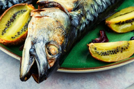 Whole tasty mackerel fish grilled with kiwi fruits.