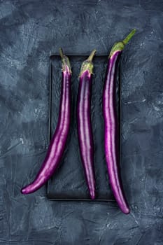 Raw colourful vibrant purple eggplants on the kitchen table. Top view